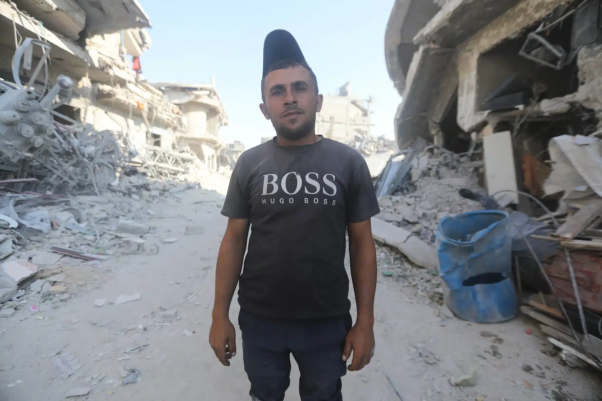 Saeed Assaf se encuentra entre las ruinas de su barrio de Jabalia, en el norte de Gaza, después de que fuera destruido por los bombardeos israelíes. (Yousef Zaanoun)